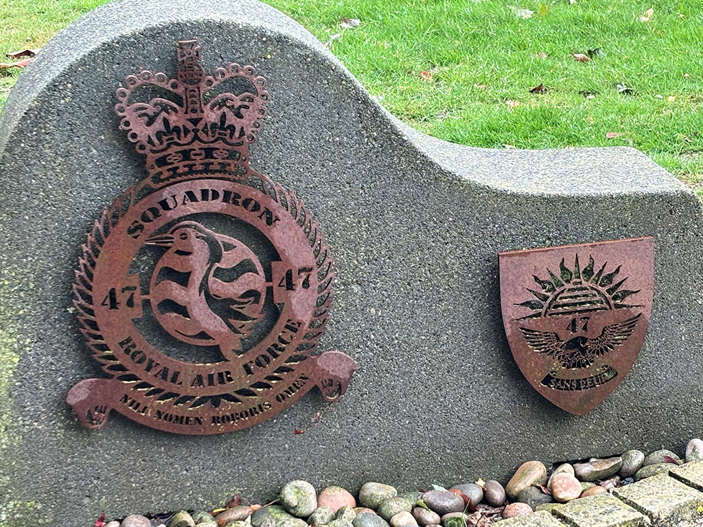 The Number 47 Squadron memorial stone, upon which, are the official Squadron badge in the centre, and additional Squadron related emblem